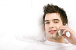 Man lying on the bed talking on the mobile phone.
