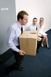 Businessman carrying a box of his belongings after being fired.