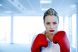Businesswoman wearing red boxing gloves.