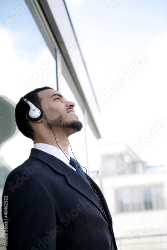Photo: Businessman listening to music on the headphones. Businessman listening to music on the headphones.