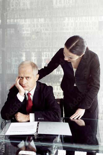 Photo: Businessman being consoled by his secretary. Businessman being consoled by his secretary.