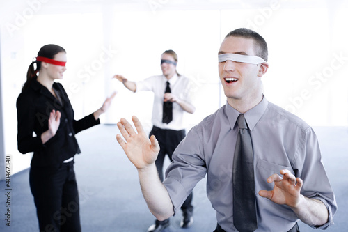 Photo: Blindfolded business people finding their ways. Blindfolded business people finding their ways.