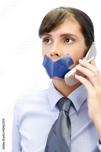 Photo: Businesswoman with her lips sealed up trying to make a phone call. Businesswoman with her lips sealed up trying to make a phone call.