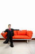 Foto: Businessman sitting on the couch with his legs crossed. Businessman sitting on the couch with his legs crossed.