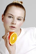 Foto: Woman holding a cut orange. Woman holding a cut orange.