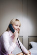 Businesswoman talking on the phone in the bedroom.