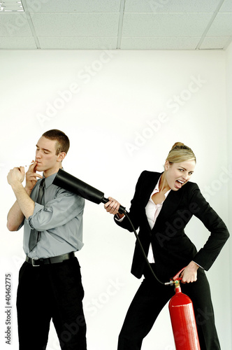 Photo: Businesswoman extinguishing her colleague for smoking in the office. Businesswoman extinguishing her colleague for smoking in the office.