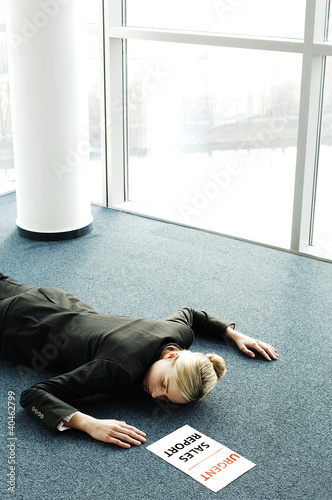Photo: Businesswoman fainted on the floor while rushing to submit an urgent sales report. Businesswoman fainted on the floor while rushing to submit an urgent sales report.