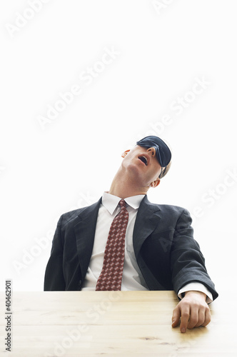 Photo: Businessman wearing eye mask sleeping. Businessman wearing eye mask sleeping.