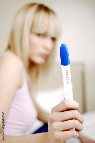 Photo: Woman showing her pregnancy test result. Woman showing her pregnancy test result.