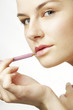 Woman applying lipstick on her lips.