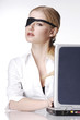 Photo: Businesswoman with eye patch using laptop. Businesswoman with eye patch using laptop.