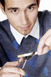 Man cutting cigarette with a scissors.