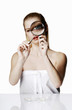 Photo: Woman looking at a tiny object with a magnifying glass. Woman looking at a tiny object with a magnifying glass.