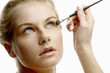 Photo: Woman applying eye shadow. Woman applying eye shadow.