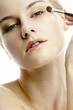 Photo: Woman applying eye shadow. Woman applying eye shadow.