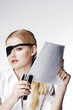 Businesswoman with eye patch stapling papers.