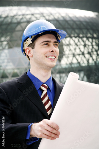 Photo: Engineer with safety helmet holding a plan. Engineer with safety helmet holding a plan.