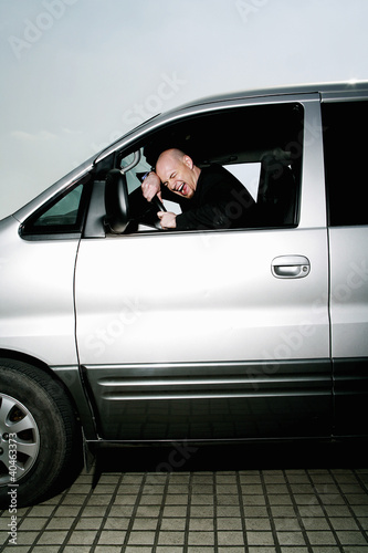 Photo: Stressed out businessman screaming in the car. Stressed out businessman screaming in the car.