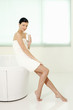 Foto: Woman sitting on the bathtub ledge holding a glass of water Woman sitting on the bathtub ledge holding a glass of water