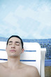 Man lying on lounge chair with his eyes closed