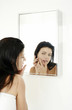 Woman checking her face on the mirror