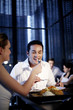Woman feeding her boyfriend while eating at a restaurant