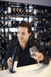 Man holding a bottle of wine and a wine glass