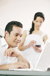 Man using laptop while his girlfriend using palmtop