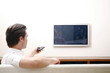 Man controlling television with a remote control