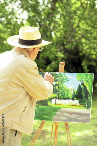 Photo: Senior man painting in the park Senior man painting in the park