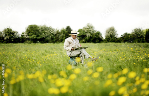 Photo: Senior man sitting on the chair drawing Senior man sitting on the chair drawing