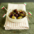 Photo: Fresh Italian olives in a small ceramic bowl with Italian flag picks sitting on a red stripy napkin Fresh Italian olives in a small ceramic bowl with Italian flag picks sitting on a red stripy napkin