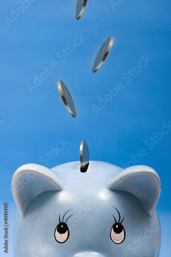 Photo: Coins dropping into a piggy bank slot Coins dropping into a piggy bank slot