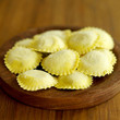 Fresh tortellini pasta on wooden board