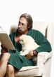 Foto: Senior man hugging his dog while reading book on the couch Senior man hugging his dog while reading book on the couch