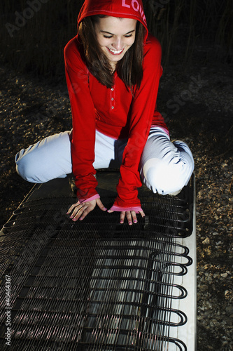 Photo: Woman smiling while sitting on the back of a fridge Woman smiling while sitting on the back of a fridge
