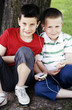 Two boys sharing a portable MP3 player