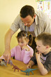 Male teacher showing his students some dinosaur figurines