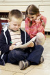 Girl watching boy drawing