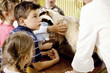 Children looking at a bear model while listening to their teacher's explanation