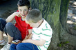 Two boys sharing a portable MP3 player