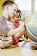 Foto: Boy and girl referring to a globe Boy and girl referring to a globe