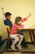 Children raising their hands to answer question