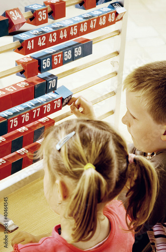Photo: Boy and girl playing with a big abacus Boy and girl playing with a big abacus