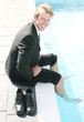 Businessman soaking his legs inside the swimming pool