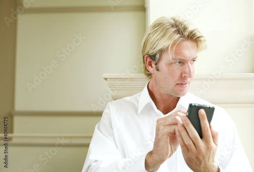 Photo: Businessman using a handheld device Businessman using a handheld device