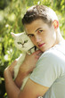 Foto: Young man holding a cat in his arms Young man holding a cat in his arms