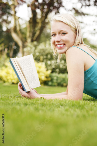 Photo: Young woman reading a book on the grass Young woman reading a book on the grass