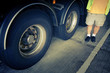 Man standing next to truck wheels
